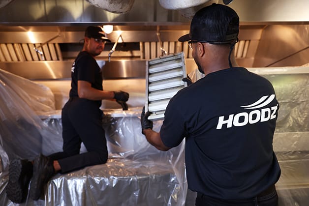 HOODZ service techs replacing hood filter