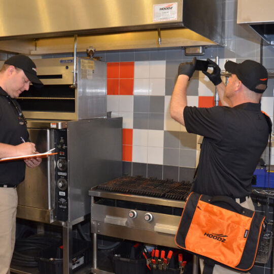 HOODZ technician performing a commercial conveyor oven cleaning service