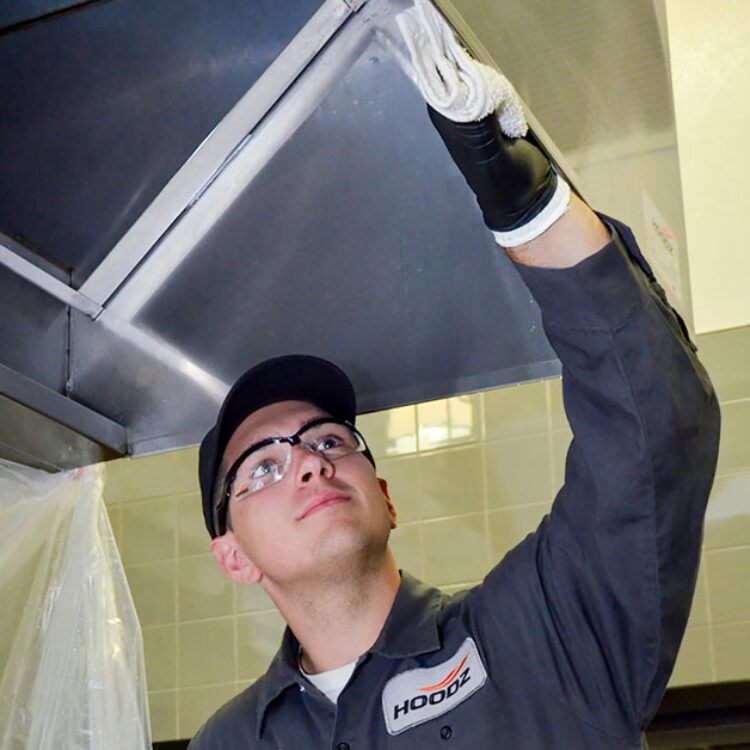 HOODZ service technician cleaning a kitchen exhaust hood