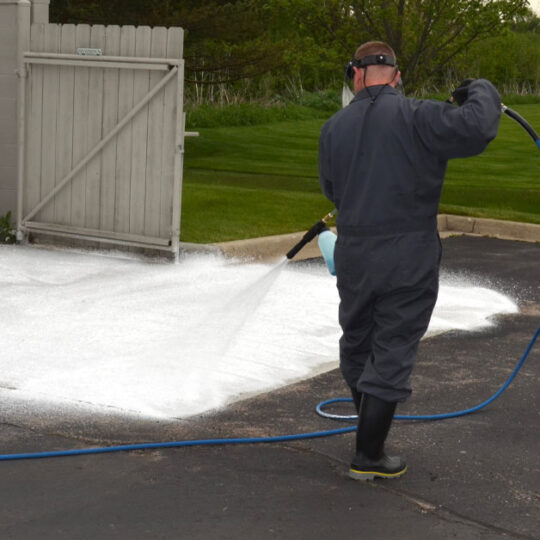 Tech cleaning concrete with a pressure washer