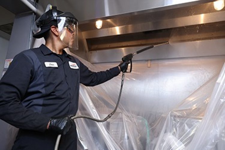 Hoodz technician spraying kitchen exhaust hood